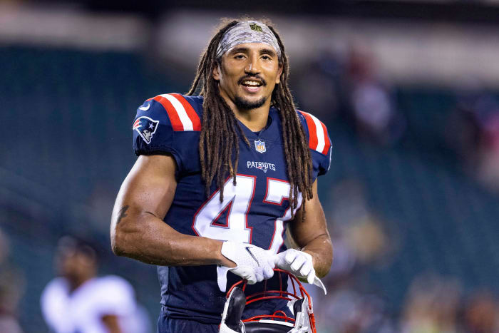 Jakob Johnson smiles while on the field for pre-game warmups